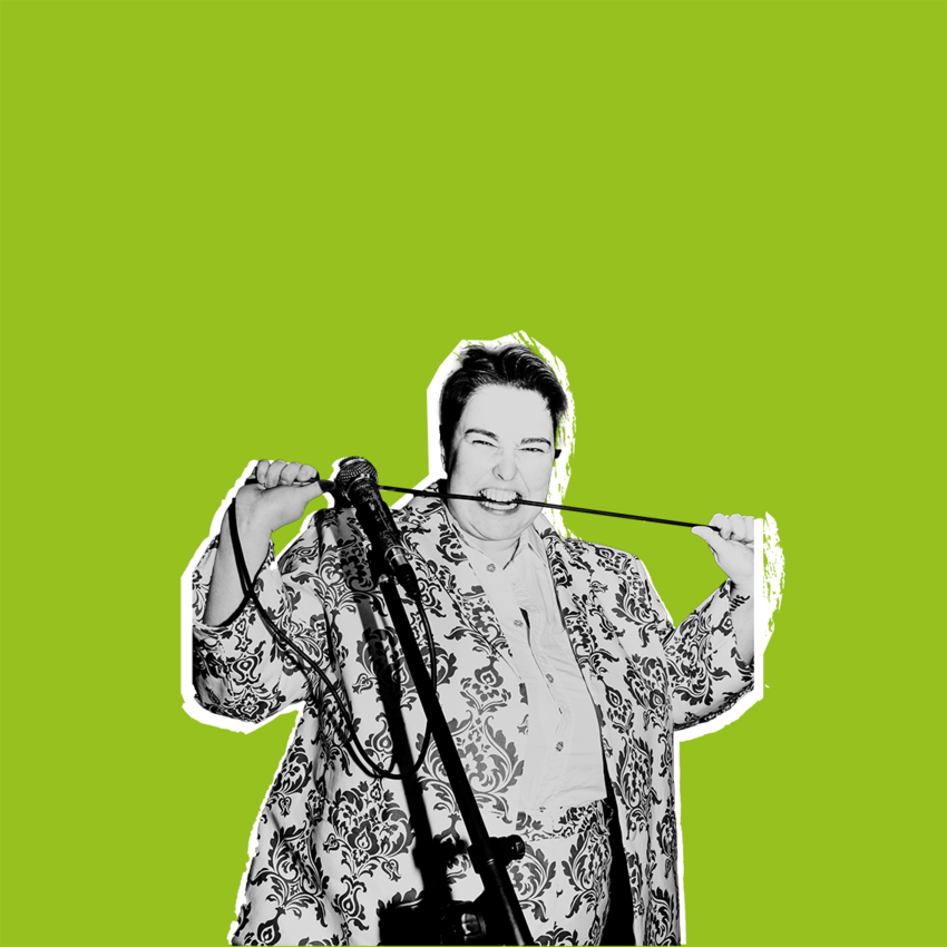 Erin Enfys wearing a patterned suit and biting down on a microphone cable. The image is overlayed on a green background as if stuck on by hand