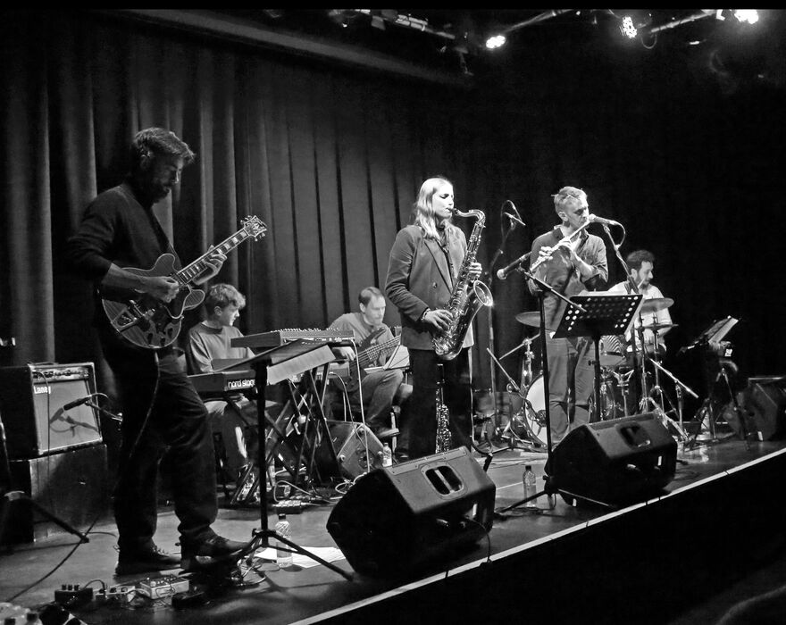 Black and white image of Emma Rawicz playing the saxophone on stage