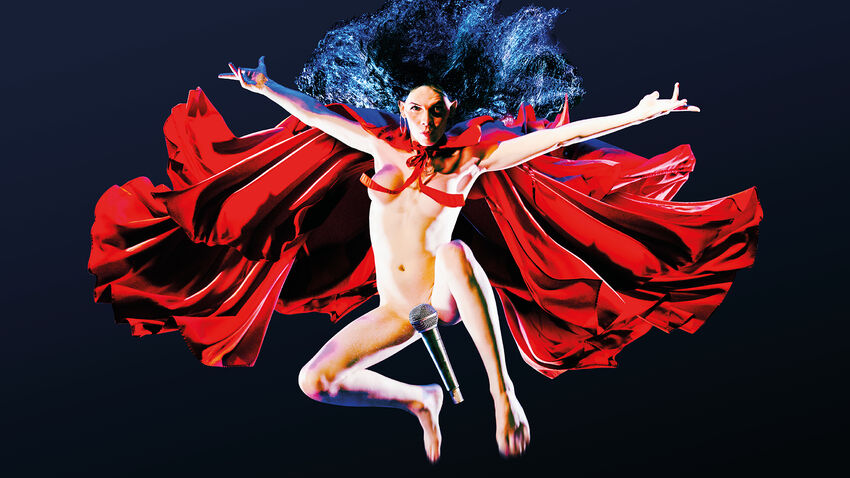 A person with long hair jump high up in the air expressing themselves