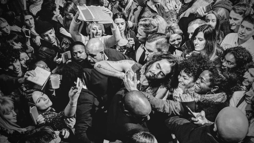 Crowd of fans surrounding Russell Brand 