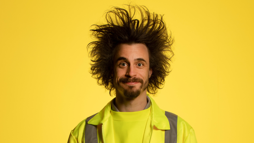 man looks directly forwards situated in a yellow background