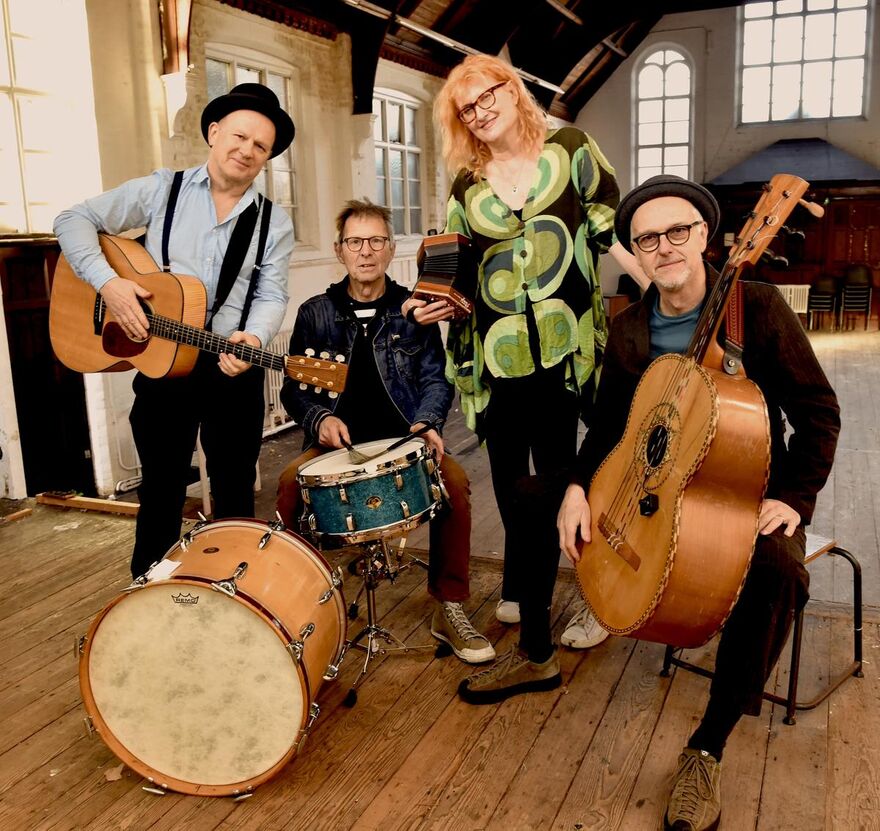 The 4 members of Fairground Attraction sat with their instruments in an airy loft