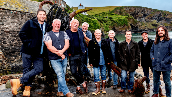 Fisherman's Friends posing for a picture together by the sea