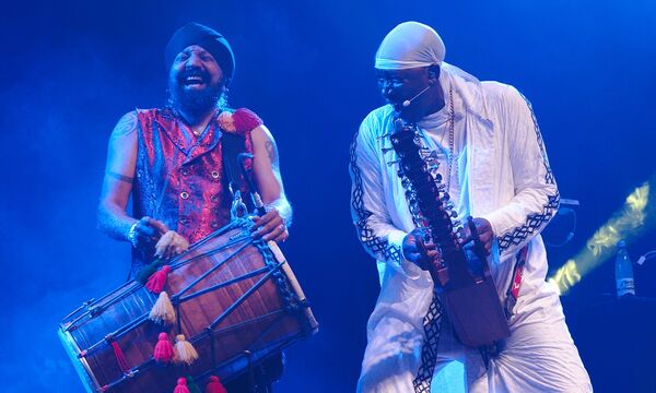 Two musicians on stage playing African instruments