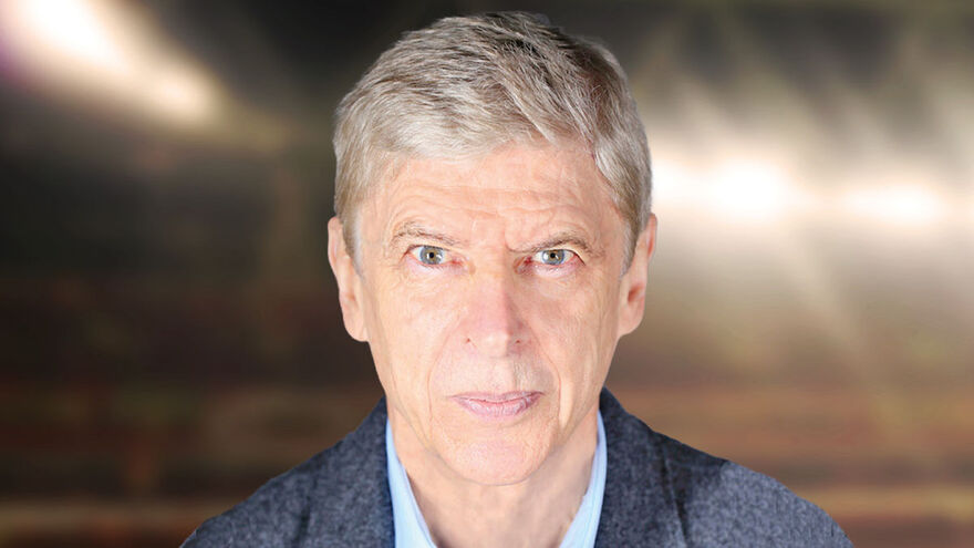 A headshot photo of Arsene Wenger against the backdrop of an out-of-focus football stadium