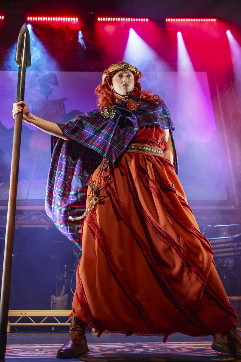 A woman dressed as Boudica stands holding a spear