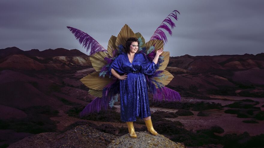 Kiri Pritchard McLean wearing a sparkly dress with large purple feathers
