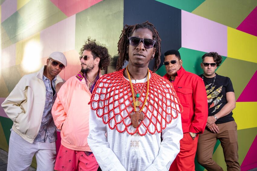 5 men standing in formation in front of a colour ful wall