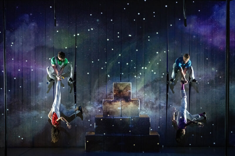 Snow is in the background as 4 performers perform circus moves