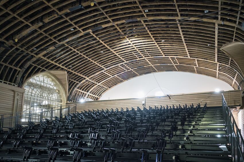 Rows of retractable seating below the grand wooden beam ceiling of the Corn Exchange