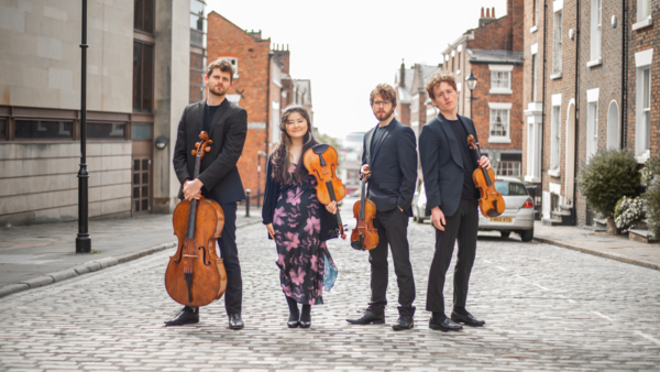 Elmore String Quartet posing in the street with instruments