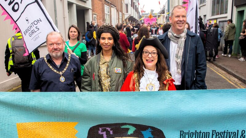 A row of 4 people standing behind the Children's Parade banner, including the Mayor, Nabihah Iqbal and Andrew Comben.