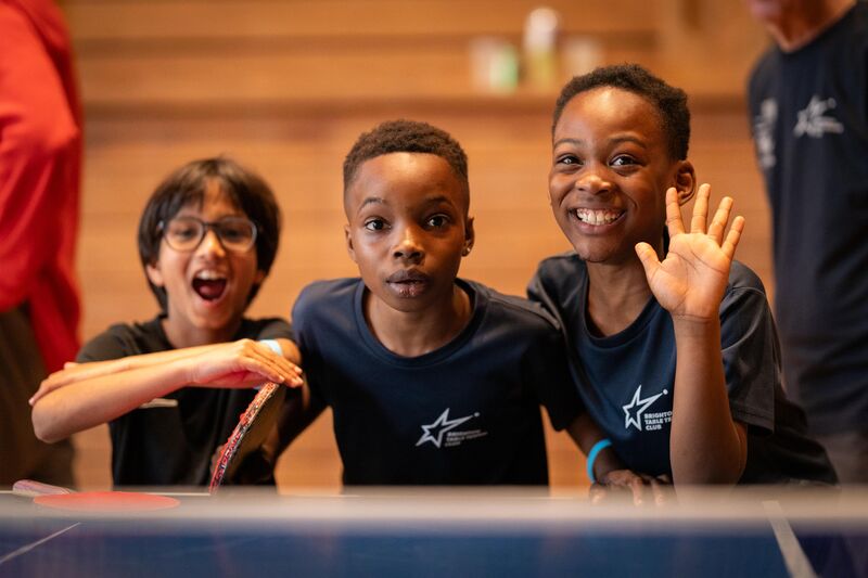 Three kids looking at the camera smiling and looking excited