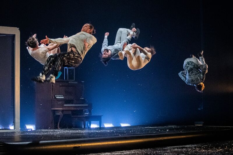 Five acrobats, mid-air, doing front and back flips