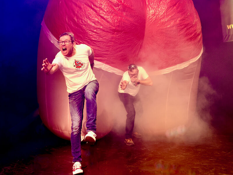 Two men run away from an inflatable bum that's releasing smelly gas