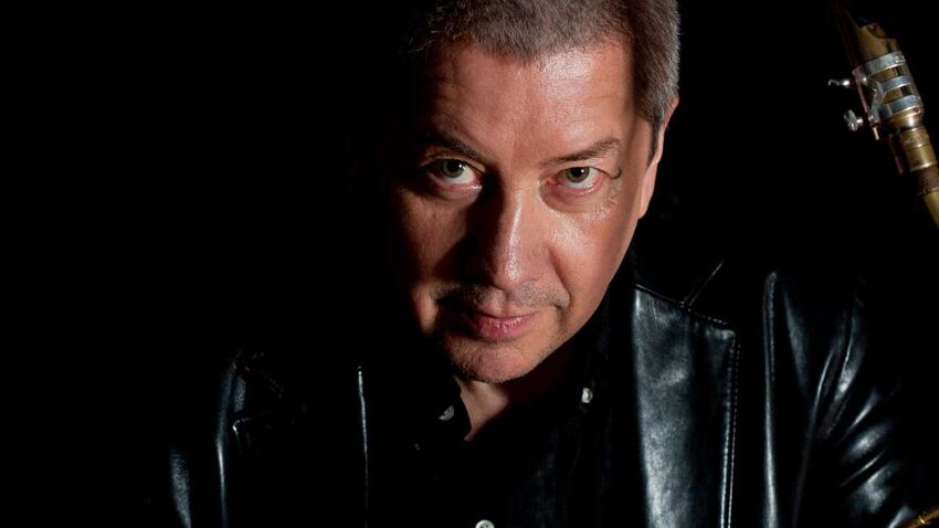 man in a dark jacket looks directly forwards