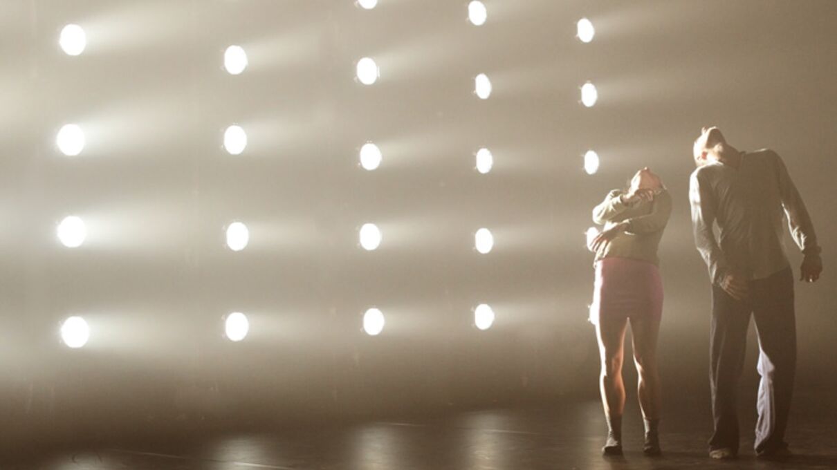 two dancers lean back to the left of the image, illuminated by many spotlights at Hofesh Shechter Company's Political Mother performed at Brighton Dome
