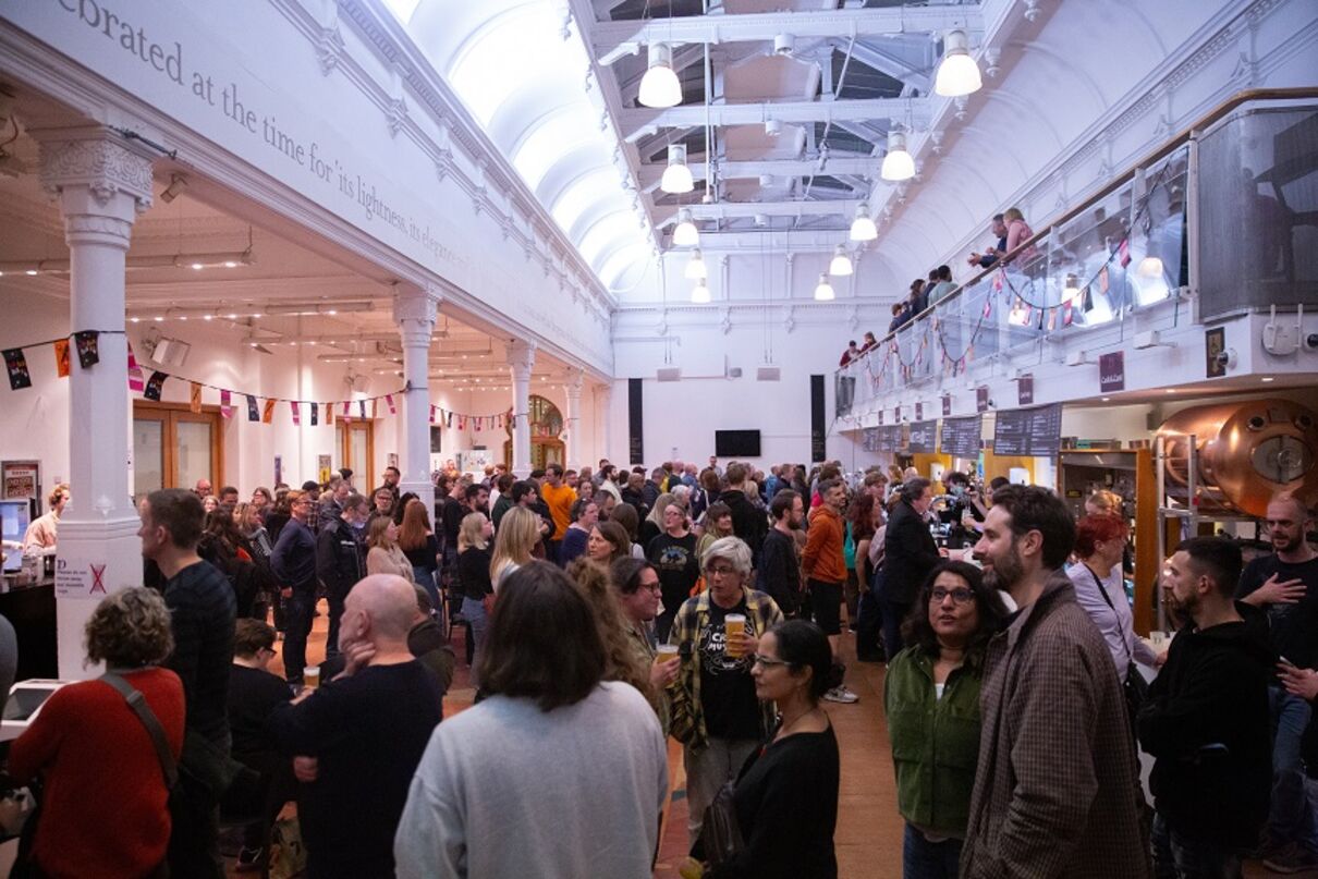 A busy Brighton Dome Bar with people standing around with drinks