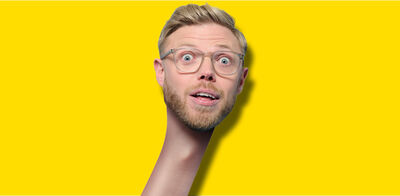 Rob Beckett's head against a yellow background. Rob has an artificially elongated neck like a giraffe. He looks surprised