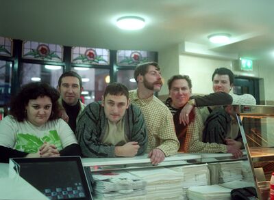 The band leaning on a counter at a fish and chip shop