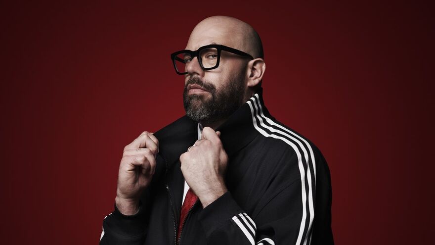 Tom Davis glances sideways to the camera, popping up the collar on his jacket