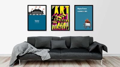 three posters hung on the wall above a grey sofa 