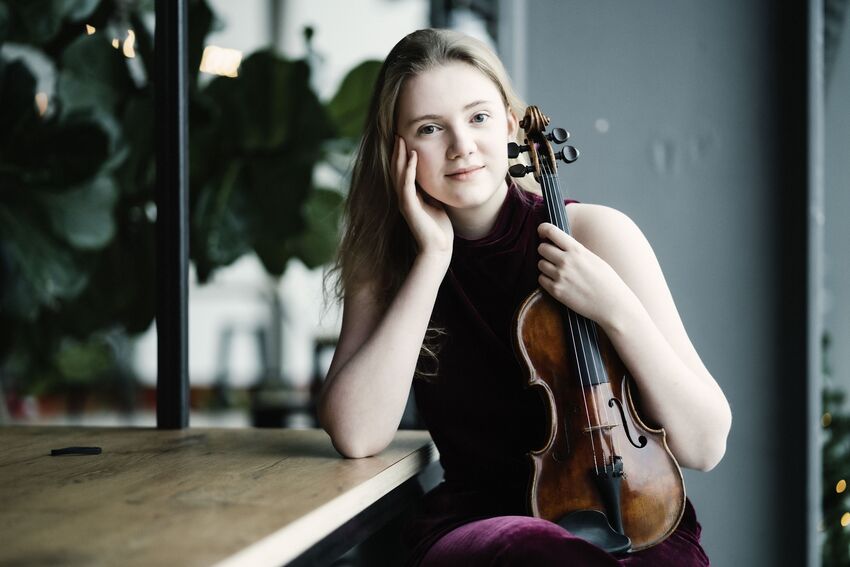 Charlotte Spruit sat at a table holding her violin