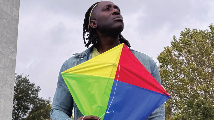 Kele Okereke holding a kite looking off into distance