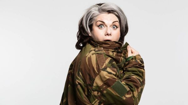 Caitlin Moran wearing a camouflage print jacket with a wide eyed look of surprise