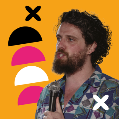 Alfie Brown holding a microphone with a funky graphic shirt