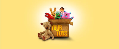 A cardboard box full of children's toys with the text 'Your Toys' written on the front 
