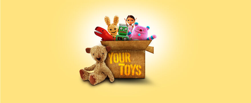 A cardboard box full of children's toys with the text 'Your Toys' written on the front 