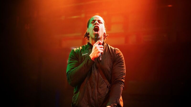 A man singing into a microphone with powerful emotion