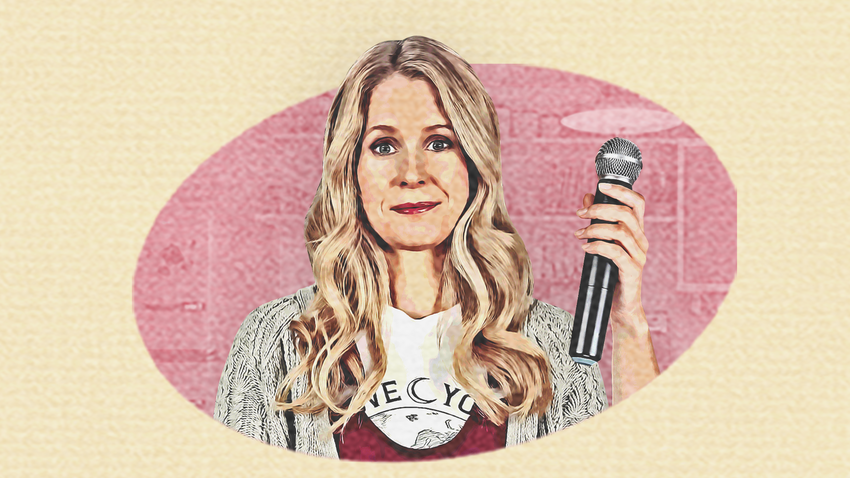 A white woman with long blonde hair holds up a microphone in her left hand