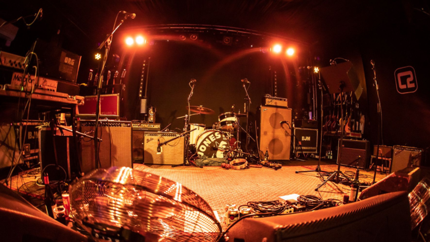 image of a rock and roll type stage with orange toned lighting
