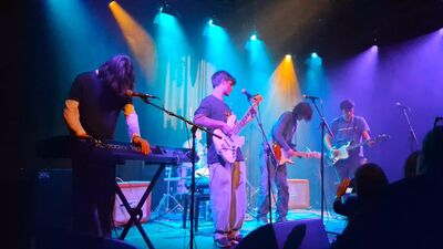 A group of young people playing in a band on stage