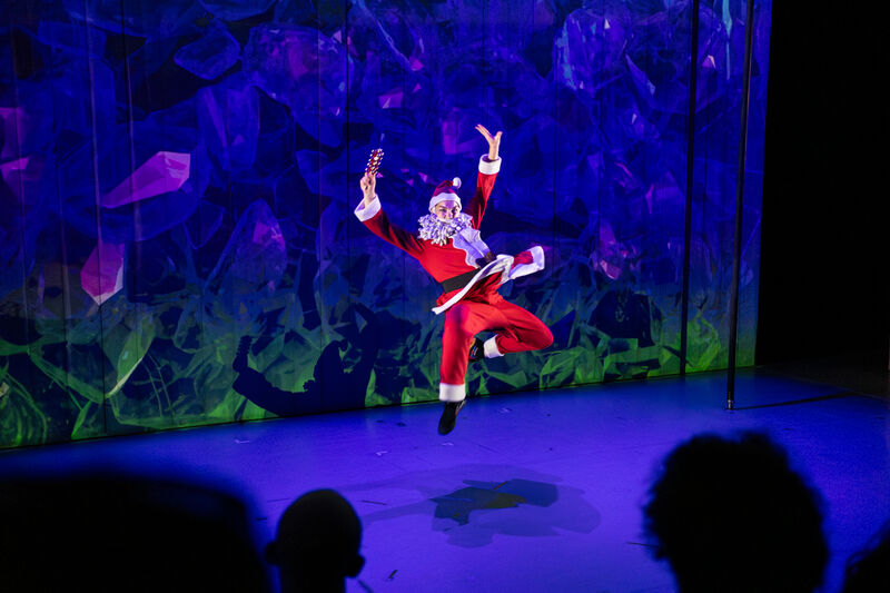 Santa dances on stage with blue lights