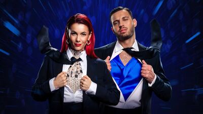 Dianne and Vito wearing black suits and ties, they are opening up their shirts to show ballroom dancing outfits underneath