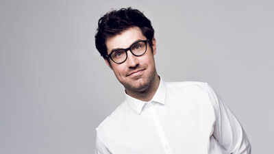Dan Schreiber in a white shirt over a grey background