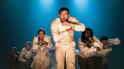 Dancers from Hofesh Shechter Dance Company face the camera intensely with arms bent 