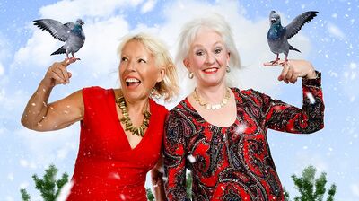 Dillie Keane and Barb Jungr standing over a snowy background holding two turtle doves!