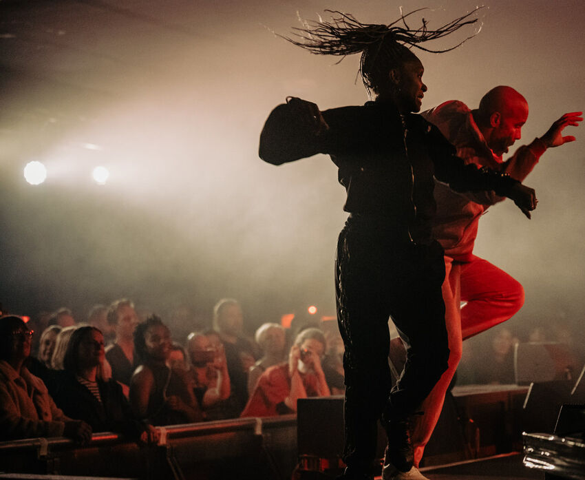 Two dancers on stage with the audience in the background
