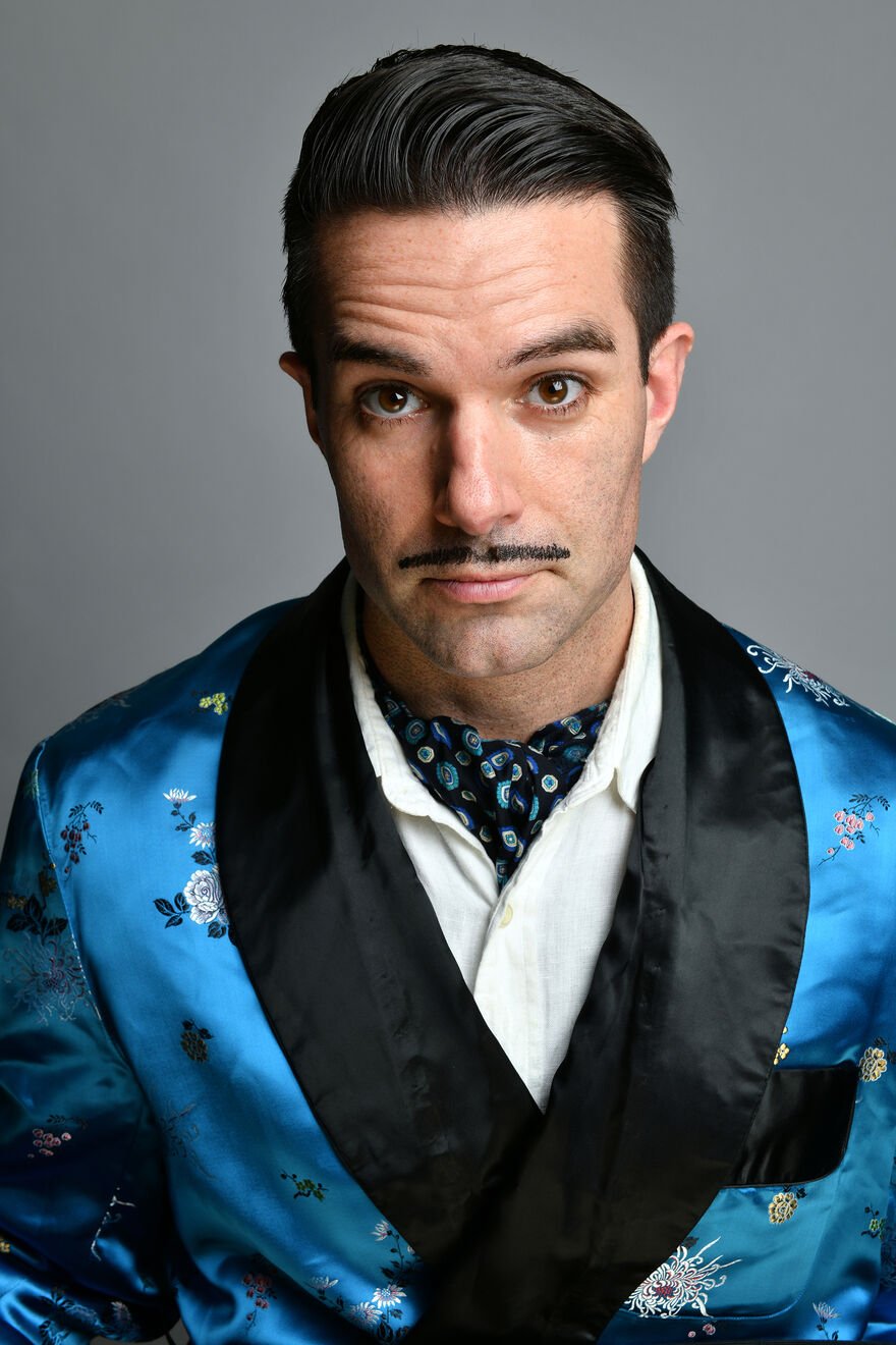 Troy Hawke wearing a blue and black blazer with a cravat