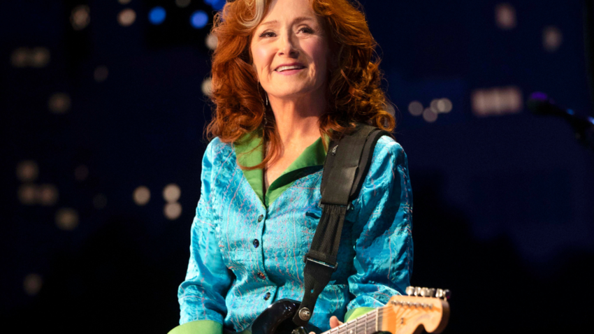 Bonnie Raitt on stage holder her guitar