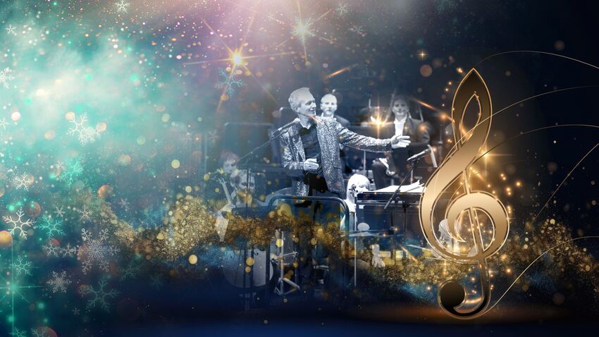 man stands surrounded by orchestra 