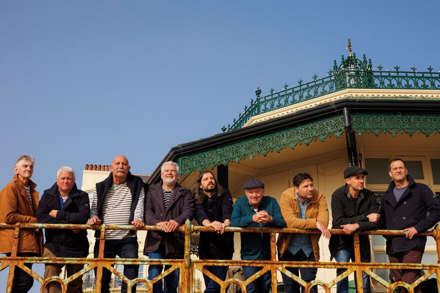 Fisherman' Friends leaning on the Brighton pier barrier 