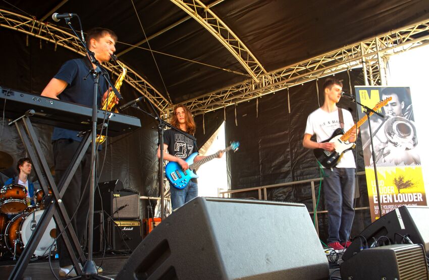four people play instruments on a stage