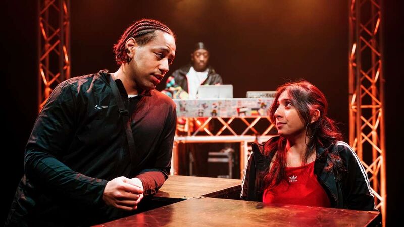 Two performers opposite each other look into each others eyes with warmth