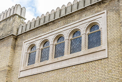 Exterior of Studio Theatre - a row of five arched windows and a brick wall