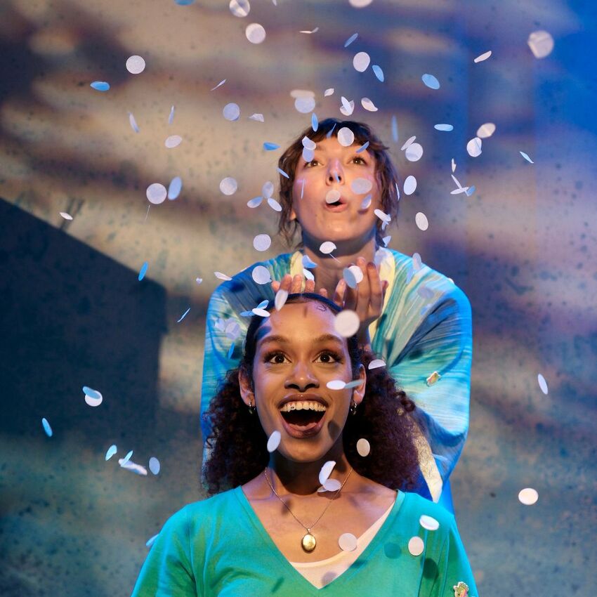 Two performers surrounded by confetti and smiling broadly
